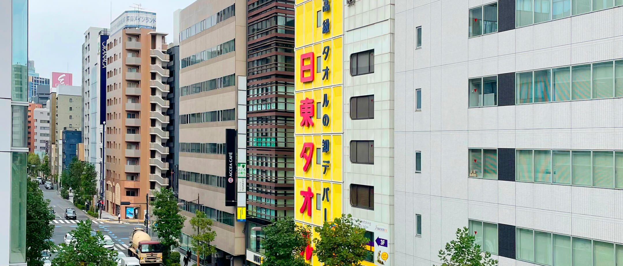 日本橋の街並みに建つ、日東タオルの黄色い本社ビル